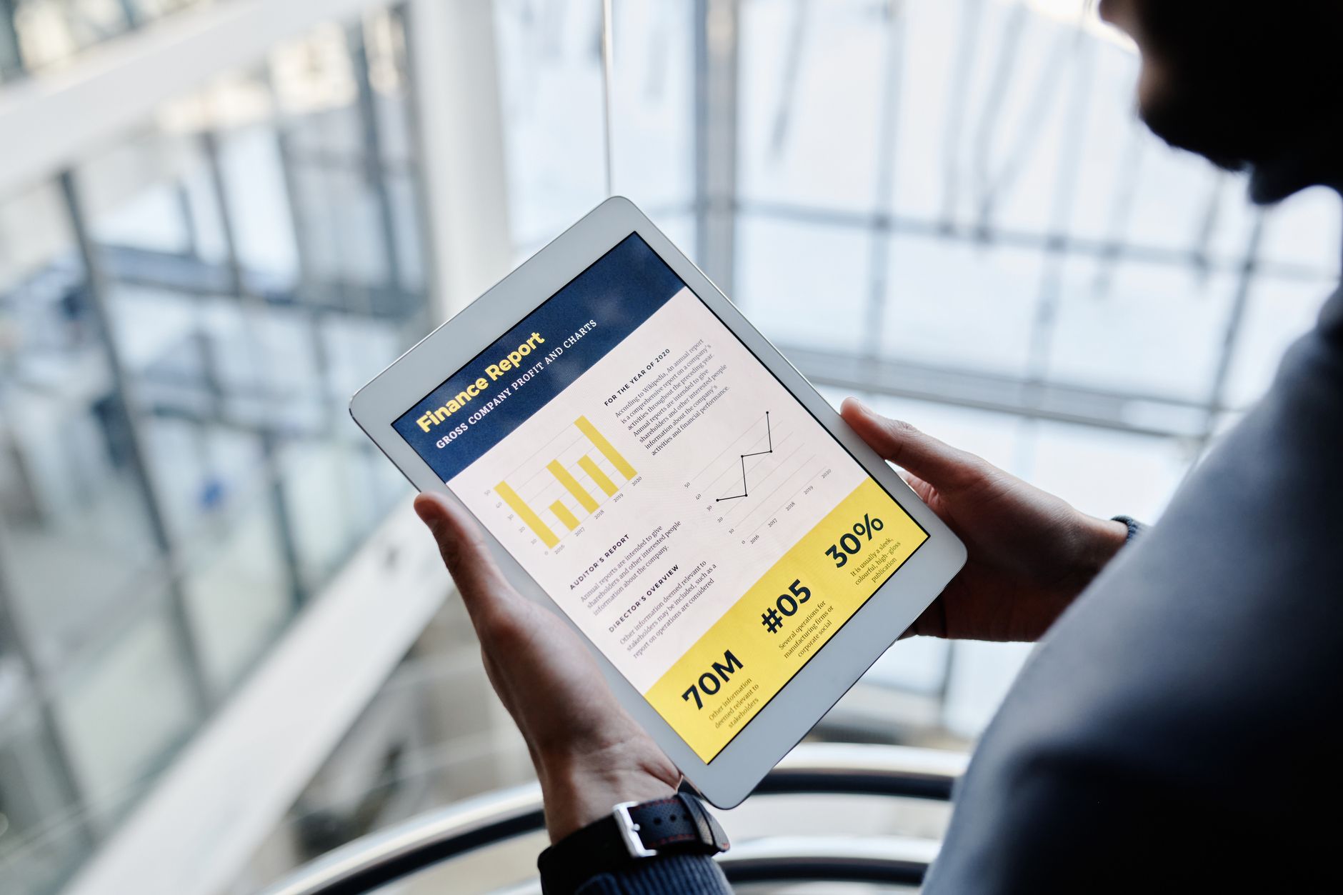 Businessman reviewing financial statistics on a tablet indoors.